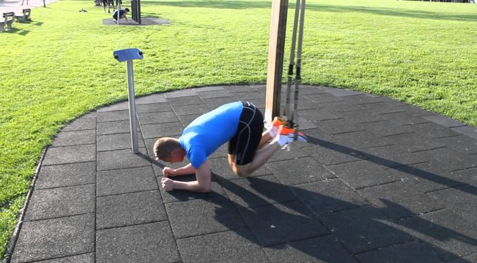 TRX príťahy kolien k hrudníku na predlaktiach v závese